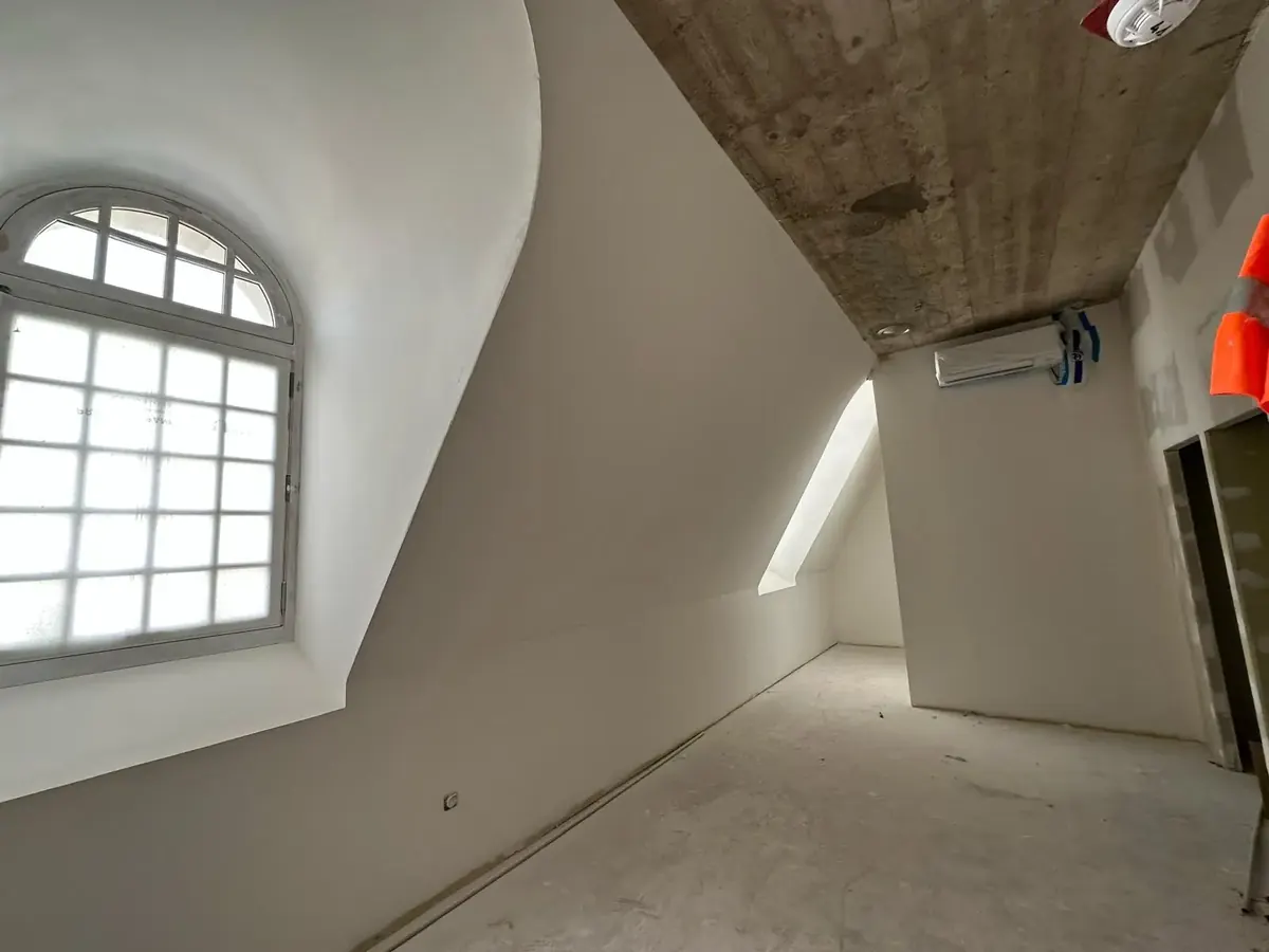 Ébrasement de lucarne cintré dans les combles du Palais du Tau, sous la dalle de béton.